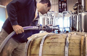 Worker filling a barrel at Elevation Brewing Company